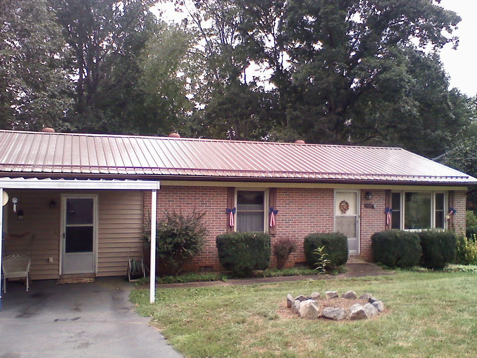 Bronze metal roof and carport on a brick ranch home — Roof Repair work by our crew in Hurricane
